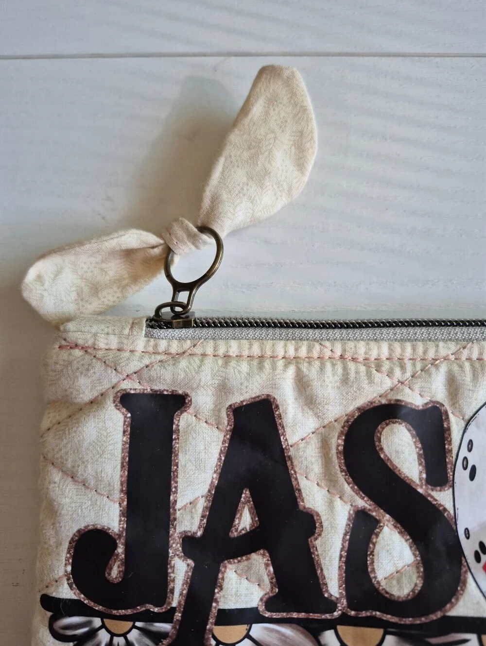 Creme slasher w/ flowers Quilted bow pouch w/ bow zipper pull accent